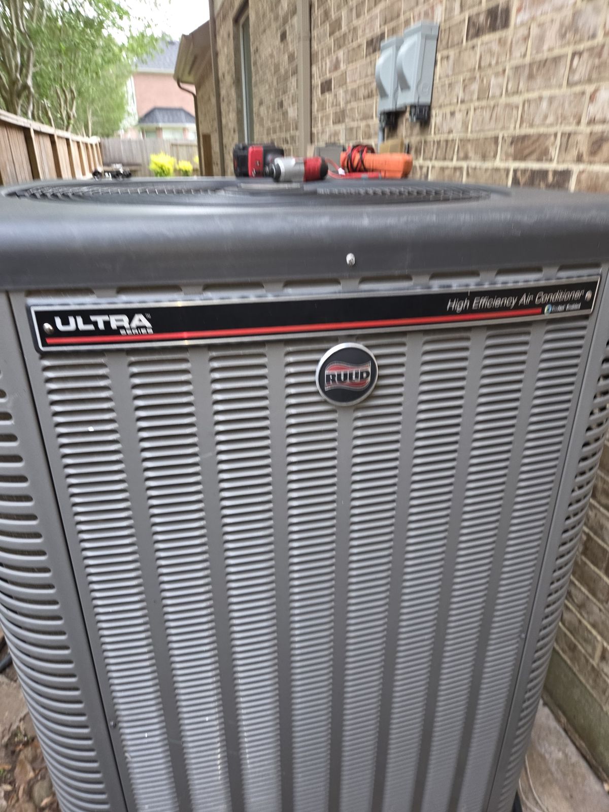 High-efficiency outdoor AC unit beside a brick wall