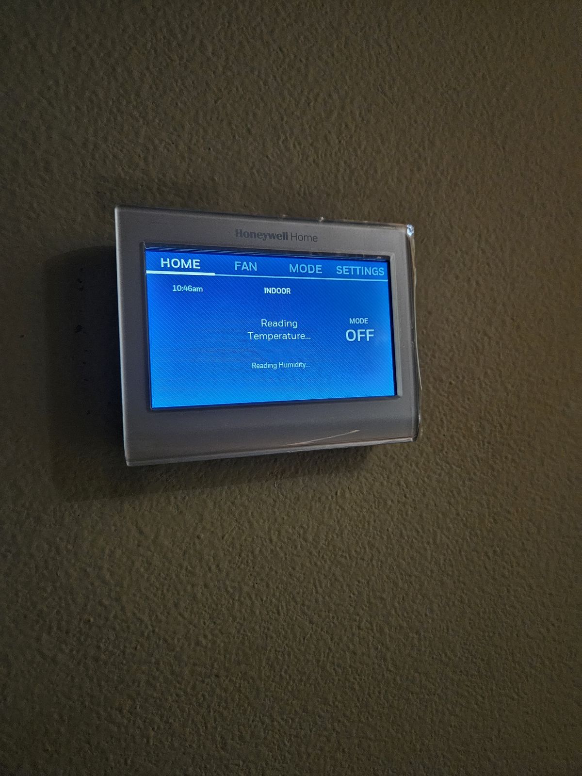 Smart touchscreen thermostat installed on a wall