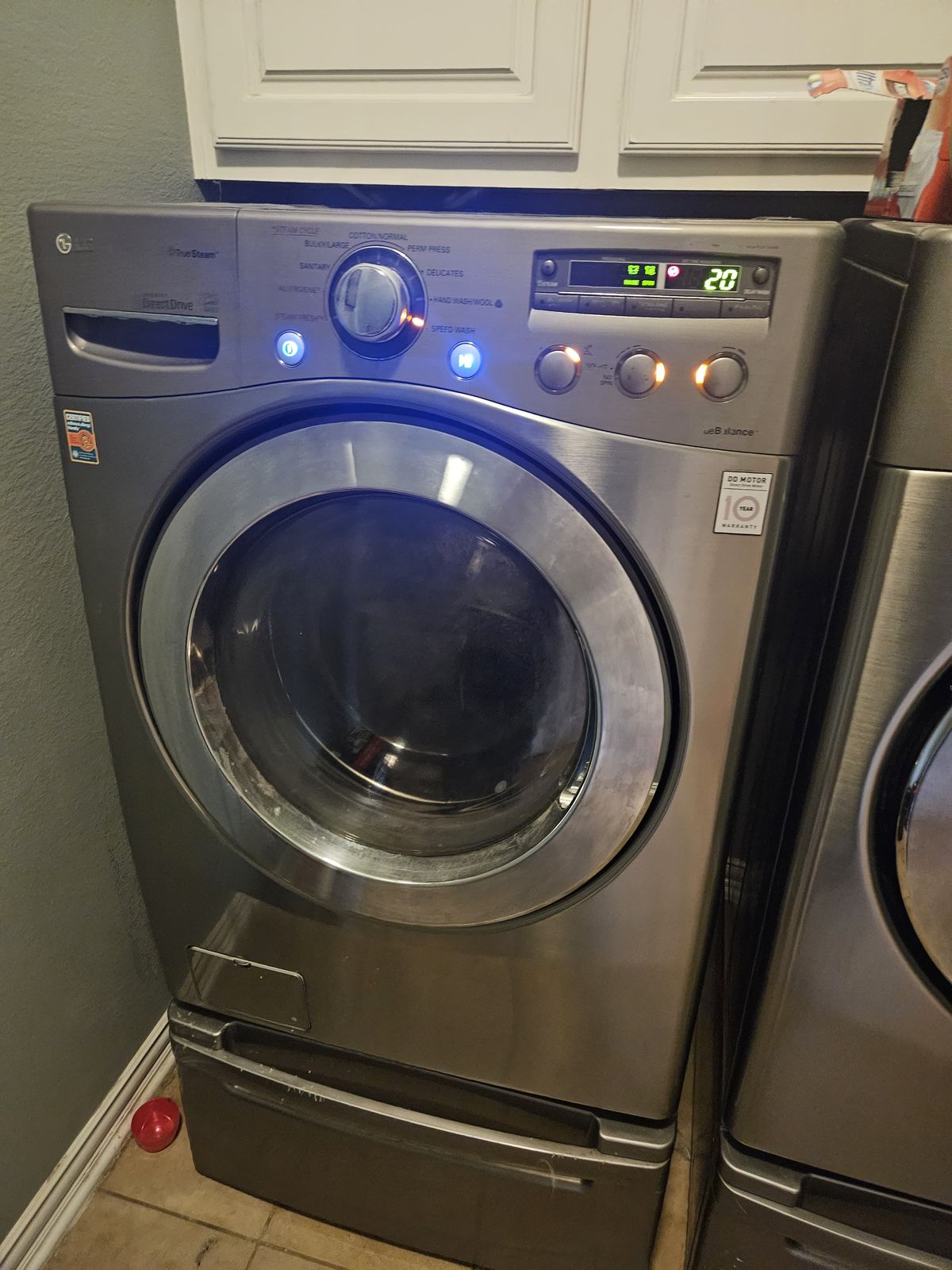 Front-load washer and dryer pair on pedestals after service
